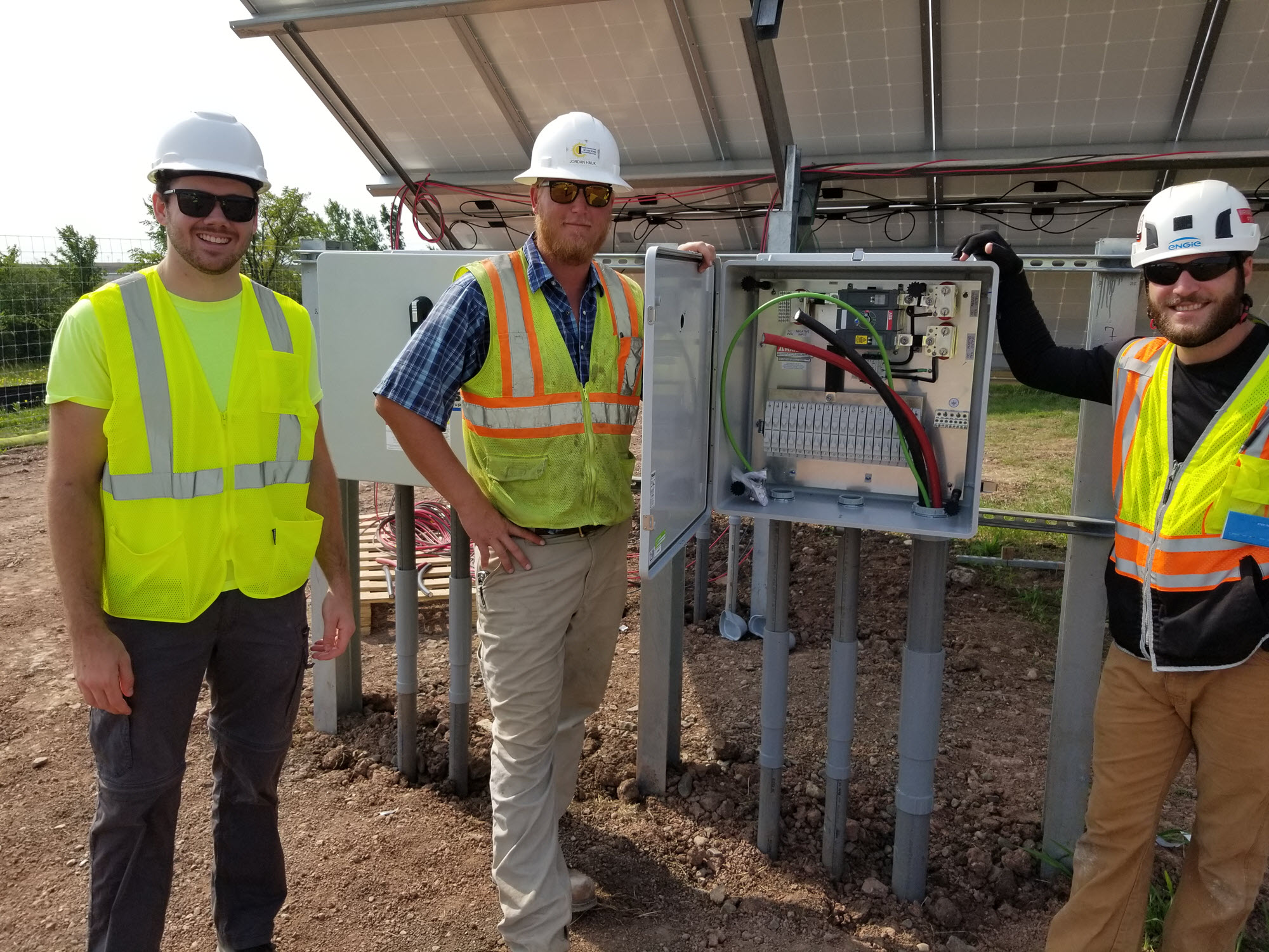 Three men standing in front of electrical box 