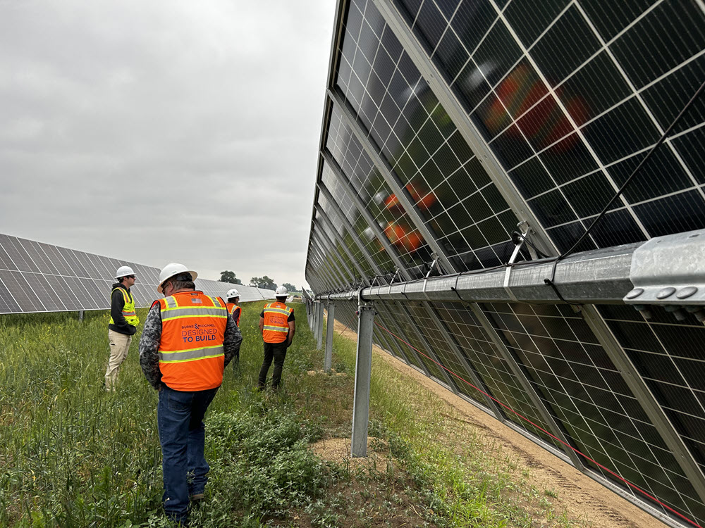 Construction workers next to solar panels