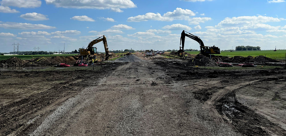 Excavators grade the project area around an access road at the Springfield Solar Project in August 2022.