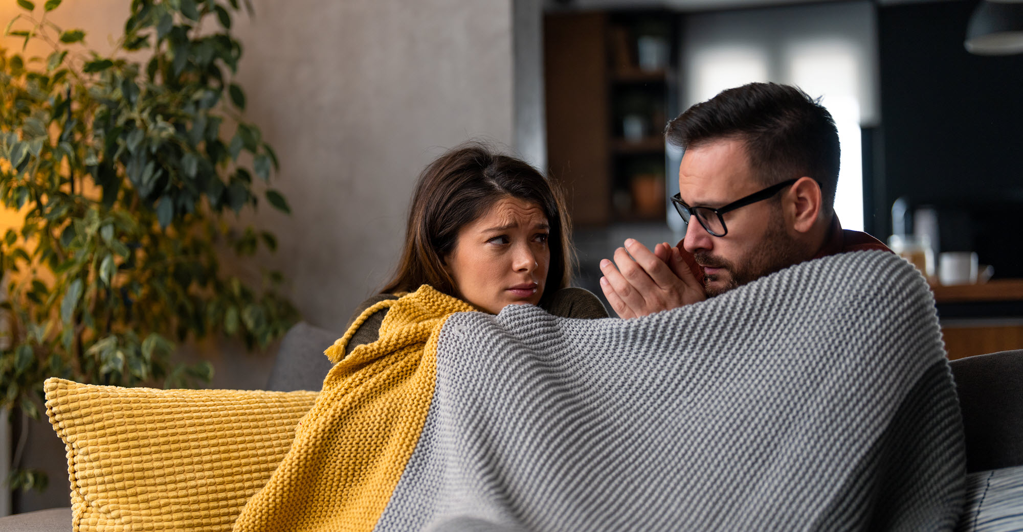 A man and a woman wrapped in a warm blanket