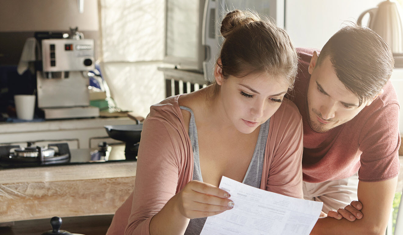 young couple looking at bill