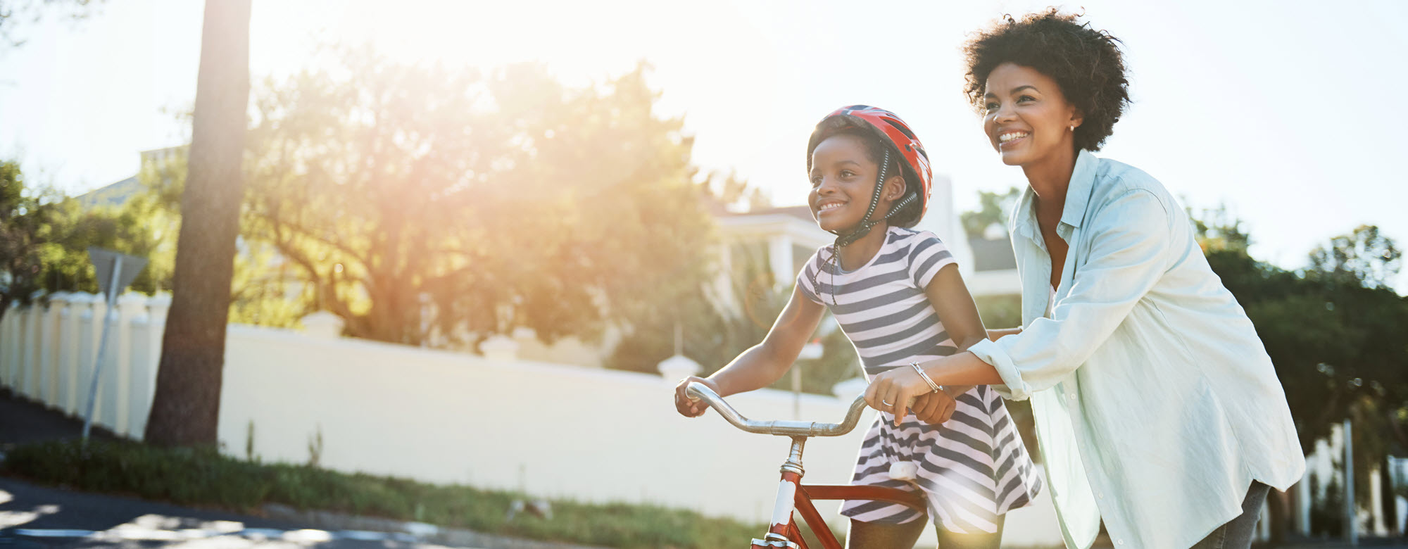 mom teaching daughter to ride a bike