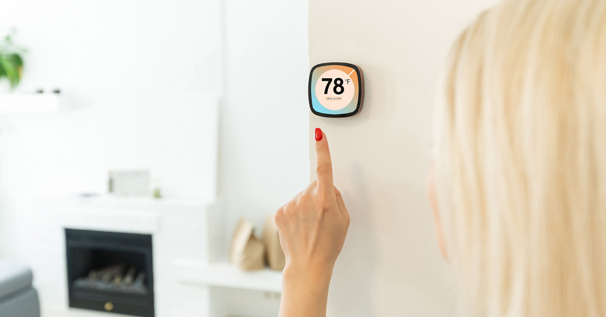 woman using a smart thermostat