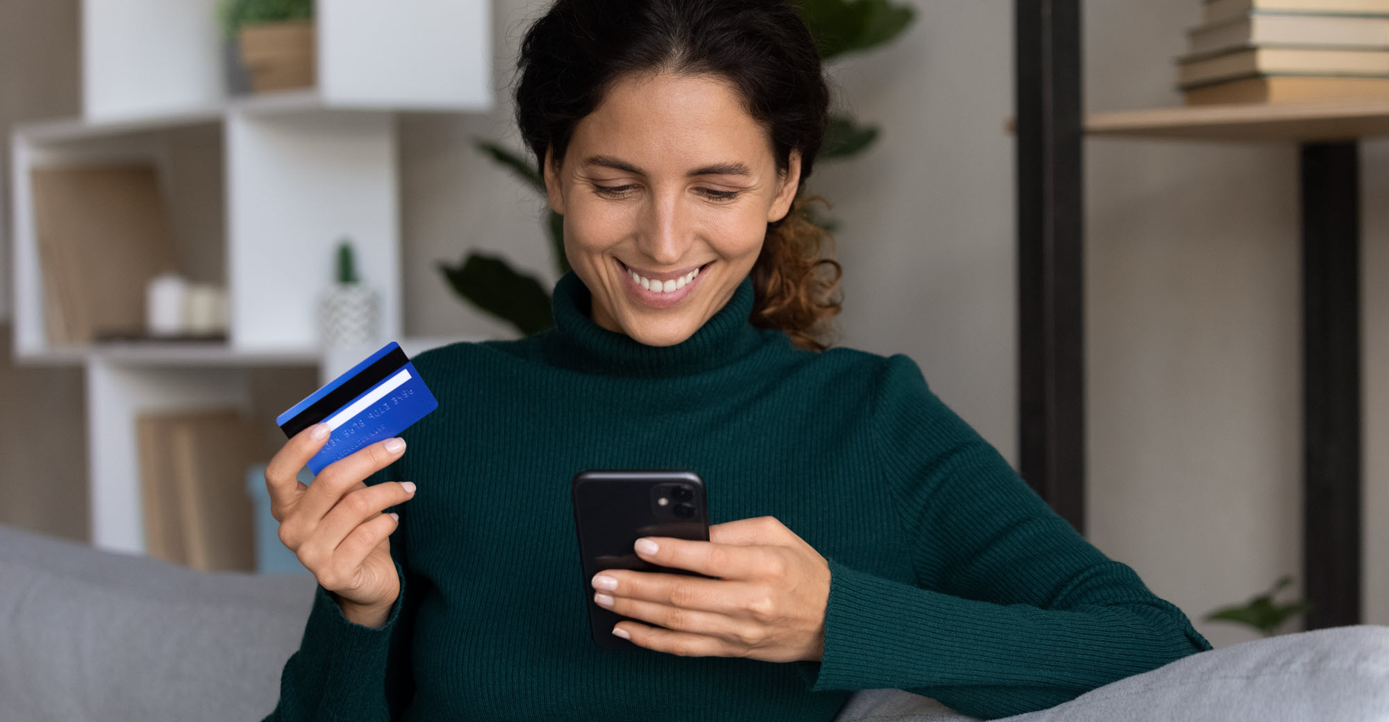 smiling woman paying a bill by phone