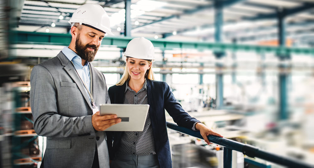 Business people in a warehouse looking at tablet