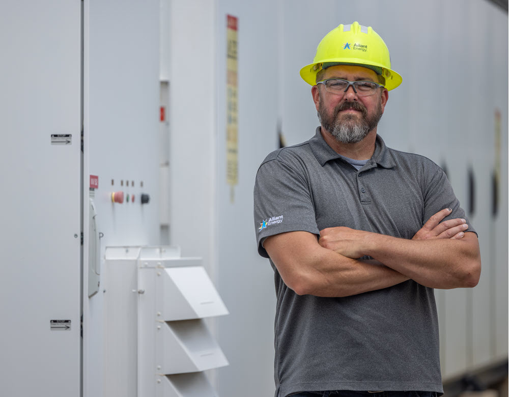 employee standing next to energy storage equipment