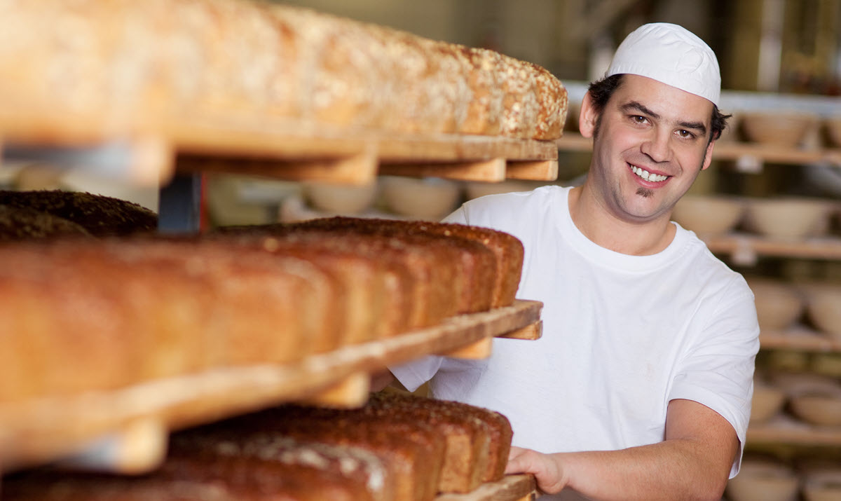 baker standing near racks of bread