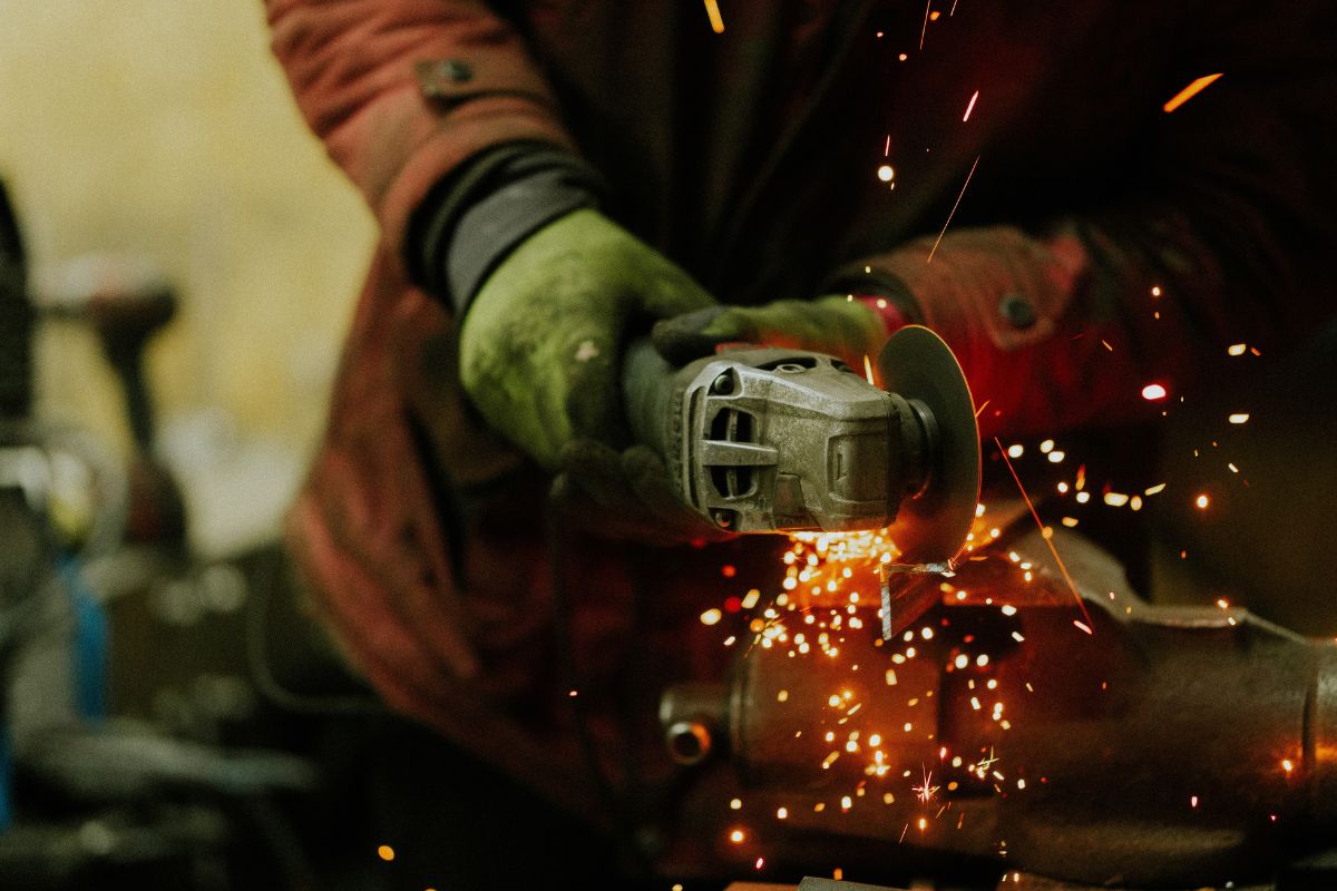 Metalworker cutting a piece of metal for car manufacturing. 