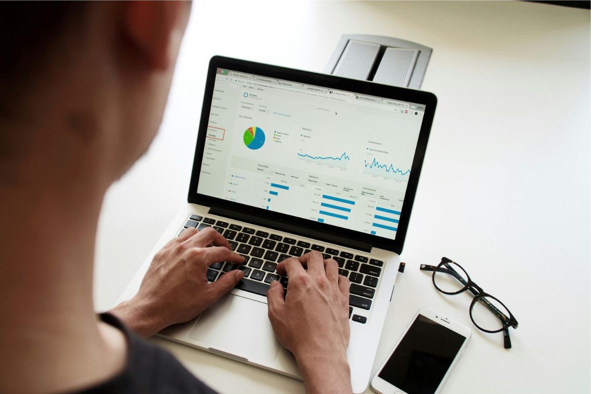 Person looking at charts and graphs on a laptop.