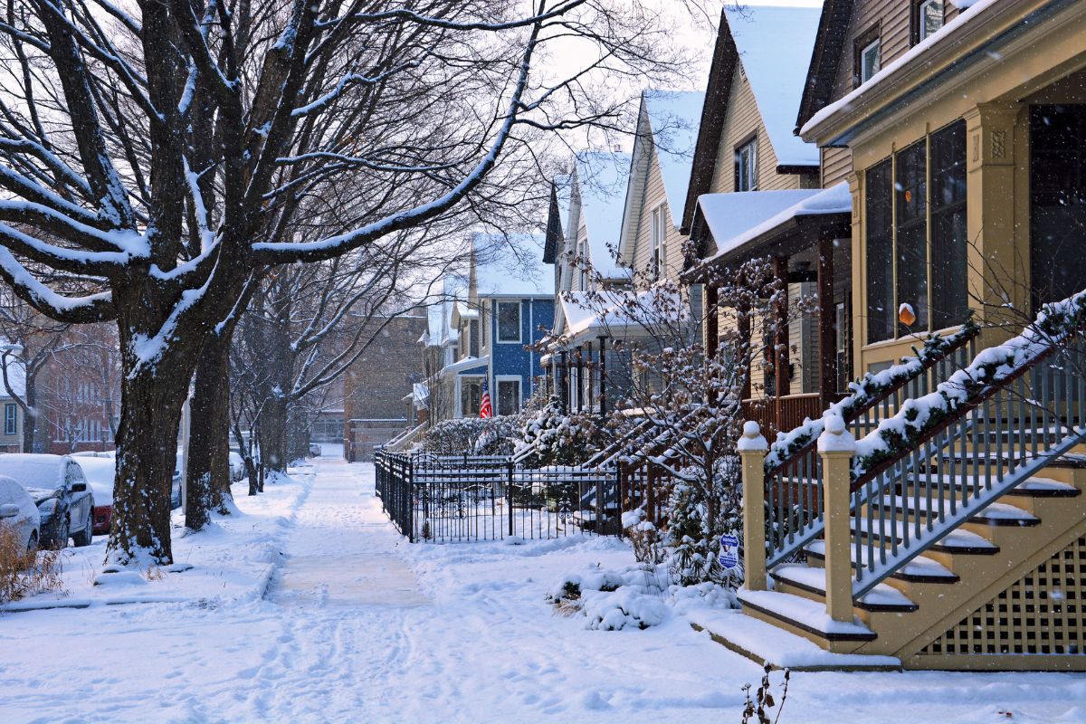 Row of snow-covered houses and trees.
