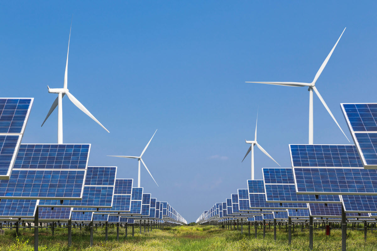 Solar farm with wind turbines in the background