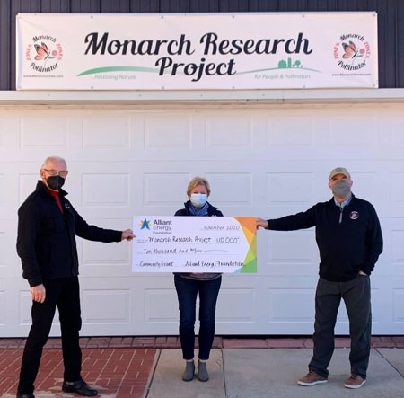 Monarch Research Project holding up big check