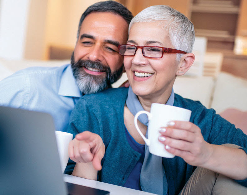 happy couple looking at laptop