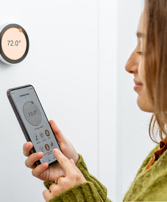 woman and a smart thermostat