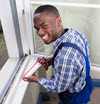 man applying caulk to window