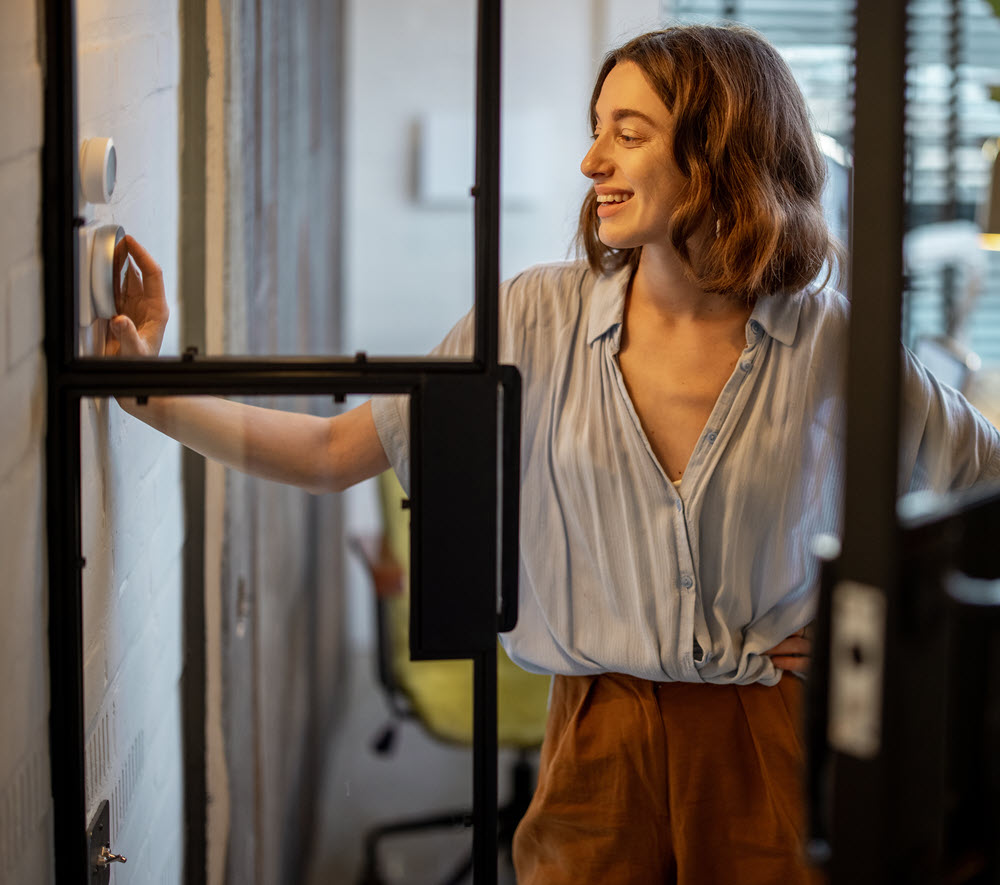 woman adjusting a thermostat