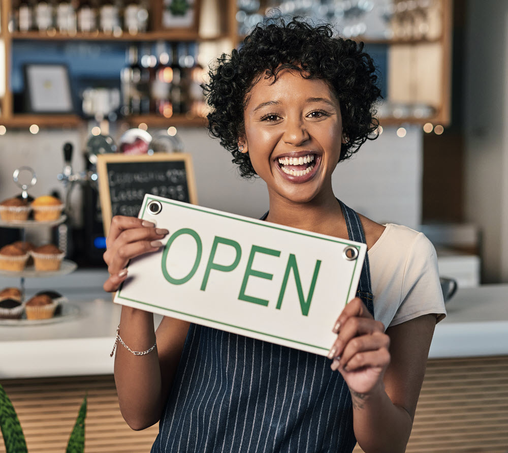 woman business owner holding an open sign