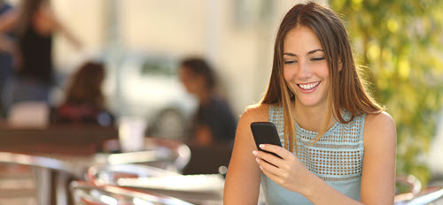 woman at a cafe looking at her phone