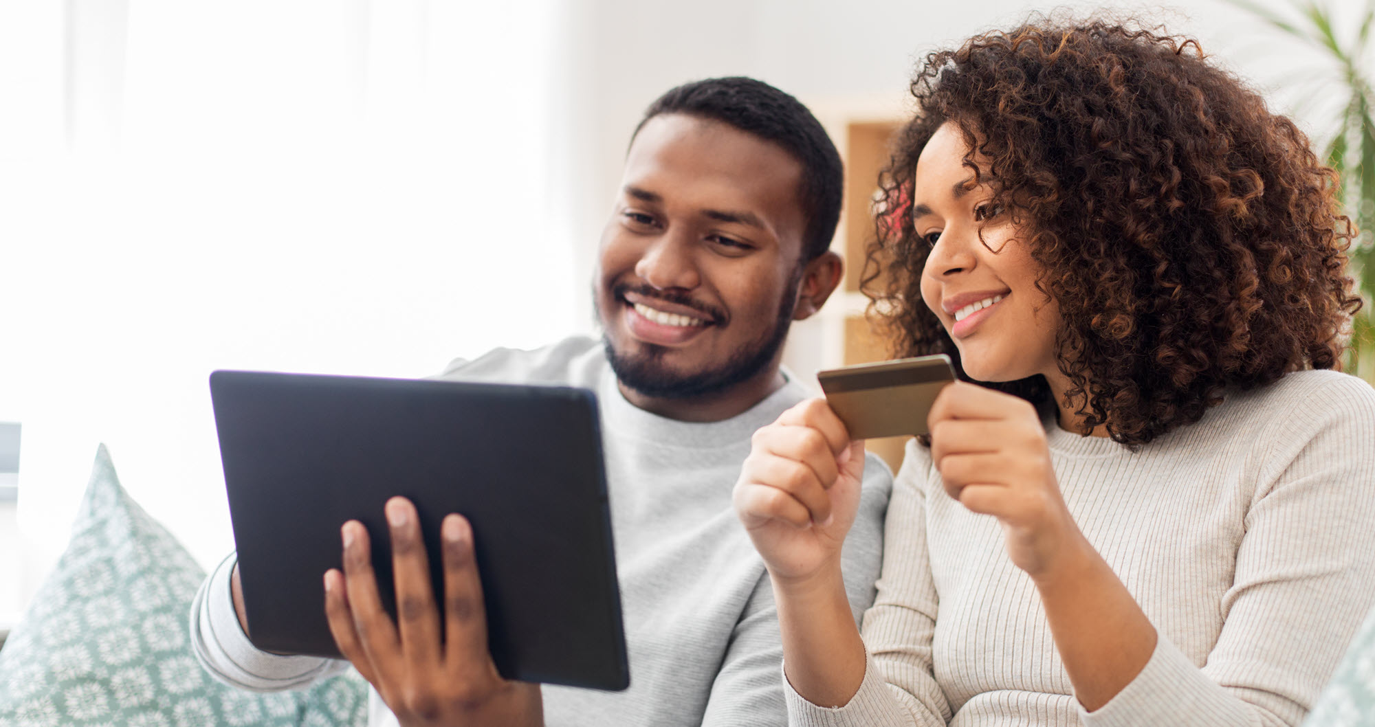 couple with a credit card and a laptop