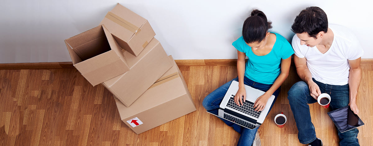 People on a laptop with moving boxes