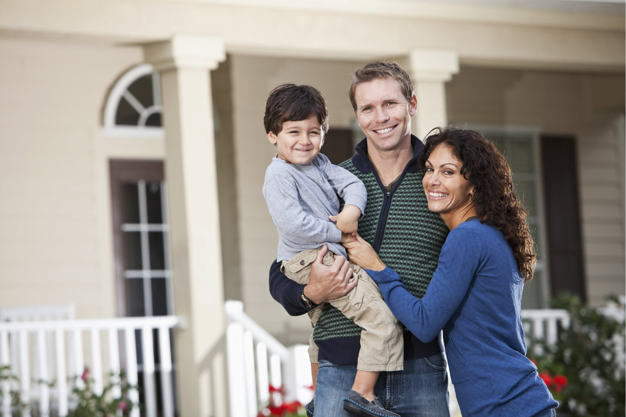 Family standing in front of house