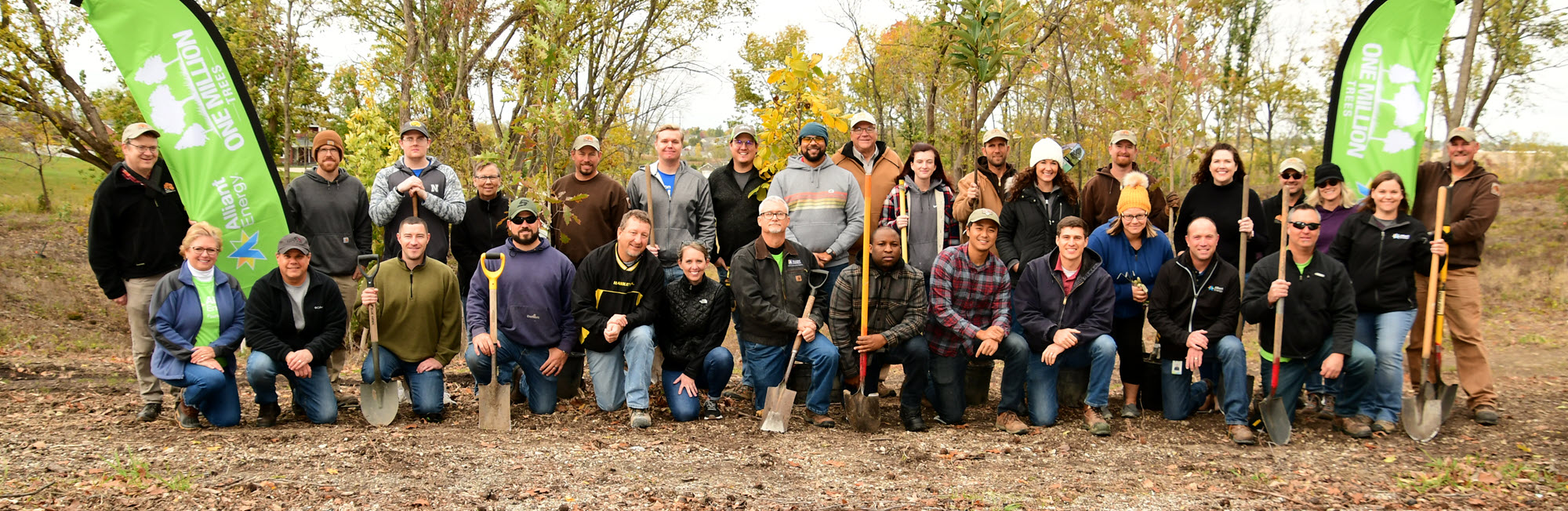 Group of people standing outside at a tree planting event