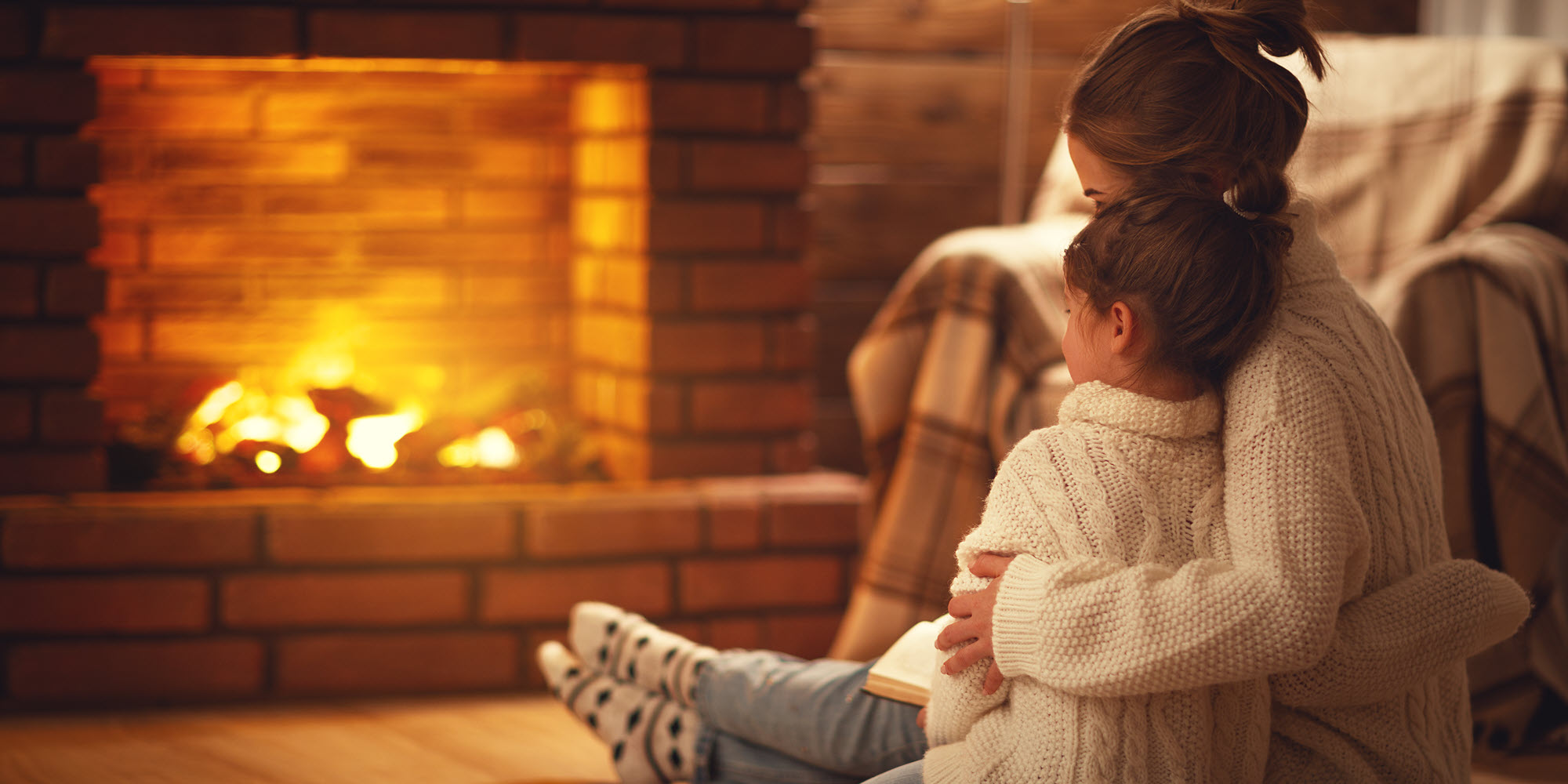mom and daughter near fireplace