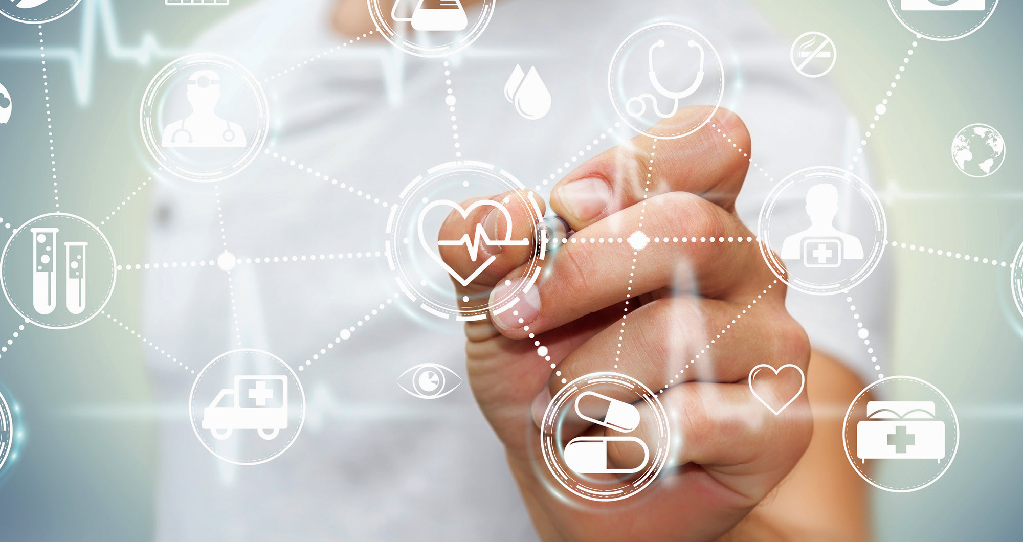 A hand writing with a collage of medical icons around it