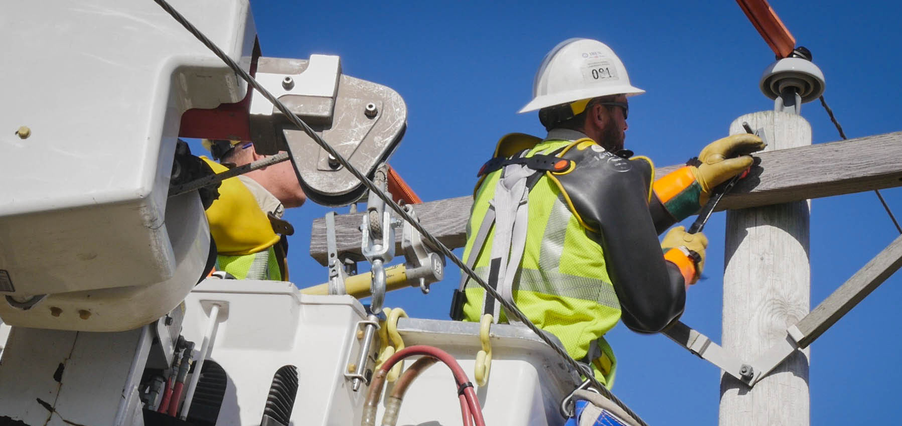 line workers working on a power pole