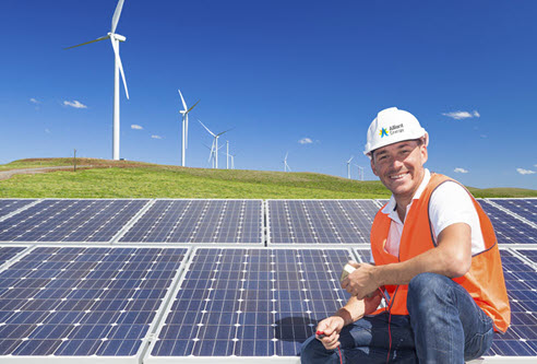 employee in front of wind turbines and solar panels