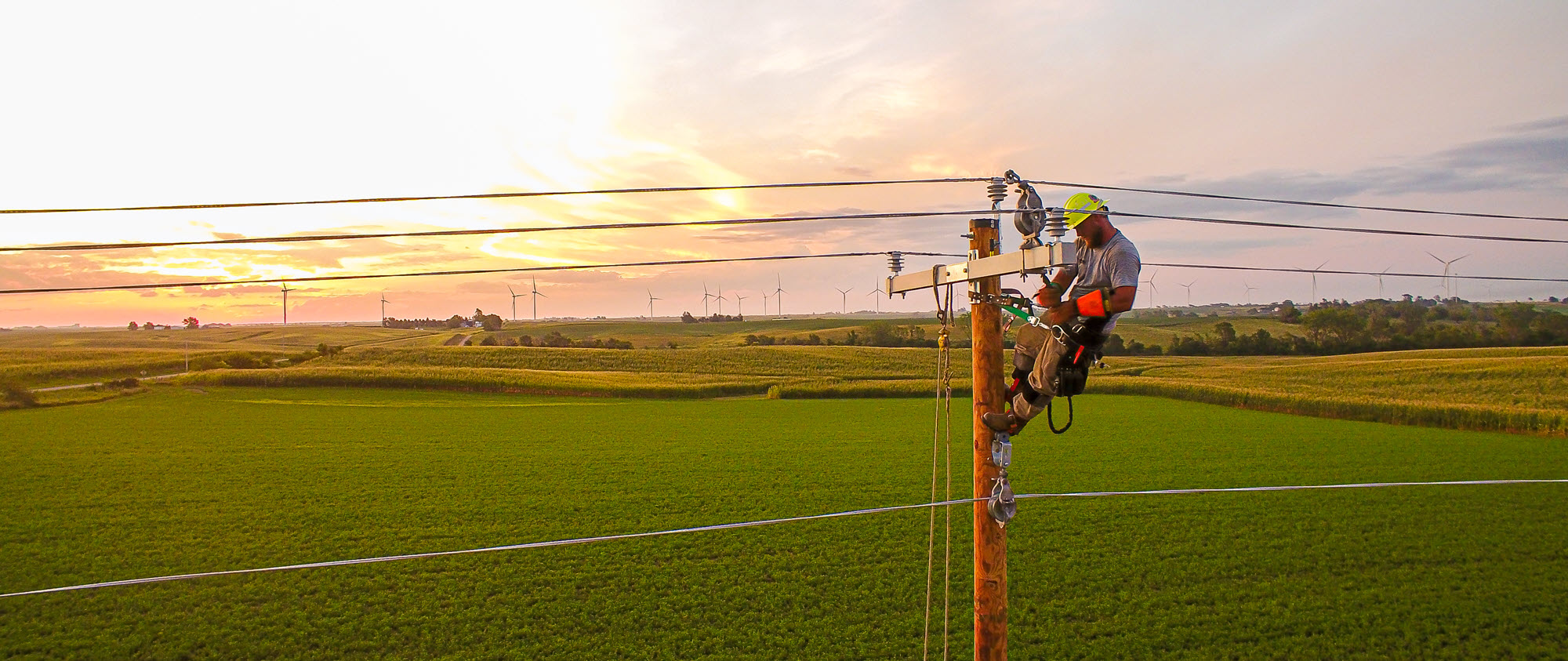 line technician working on top of a power pole