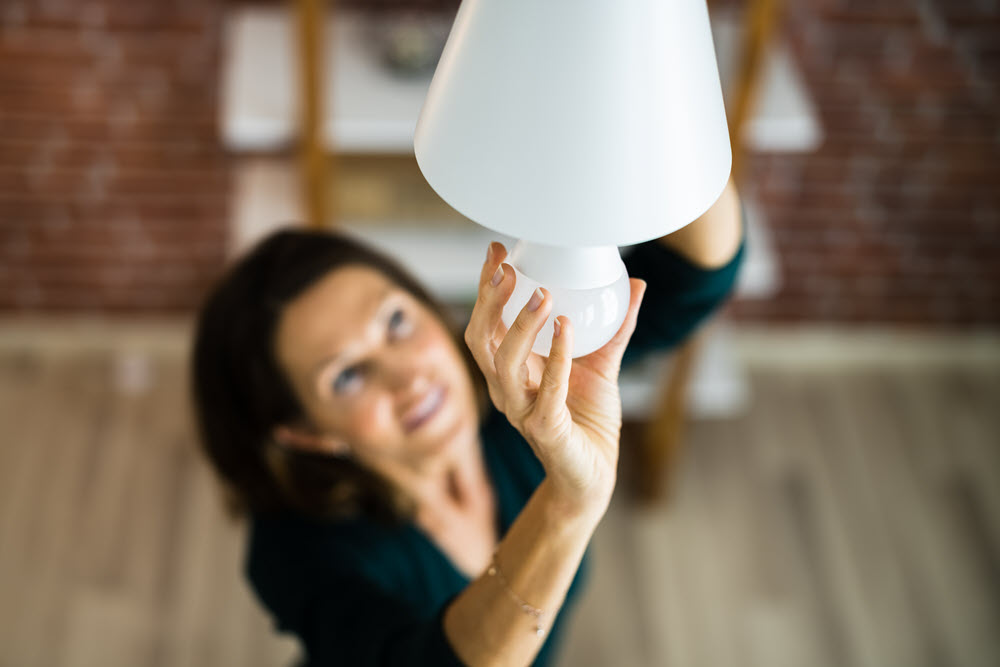 woman adding LED light bulb