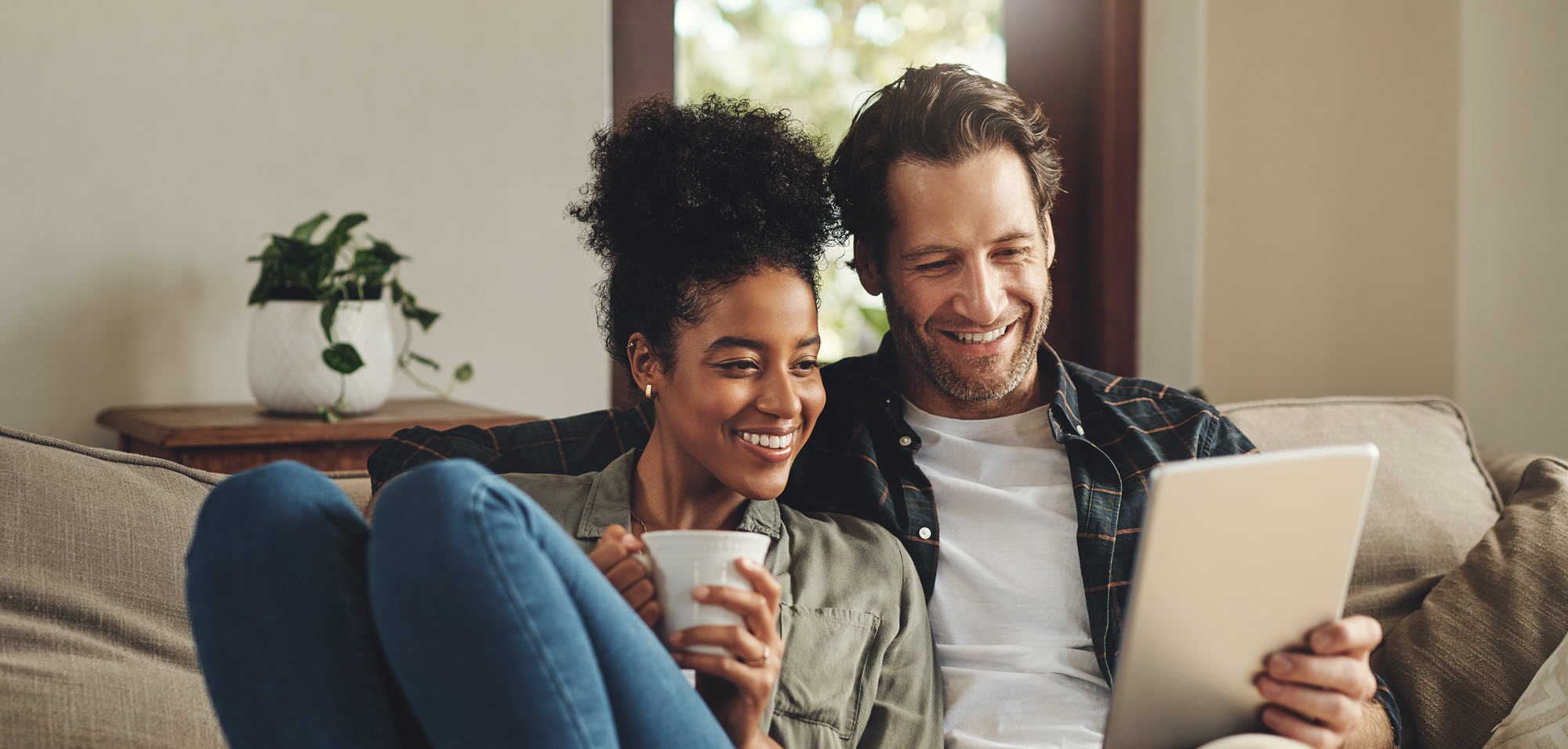 couple on couch looking at tablet