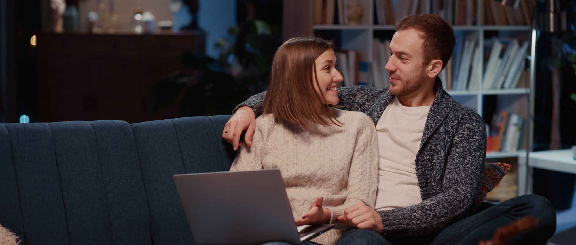 couple on a couch looking at a computer