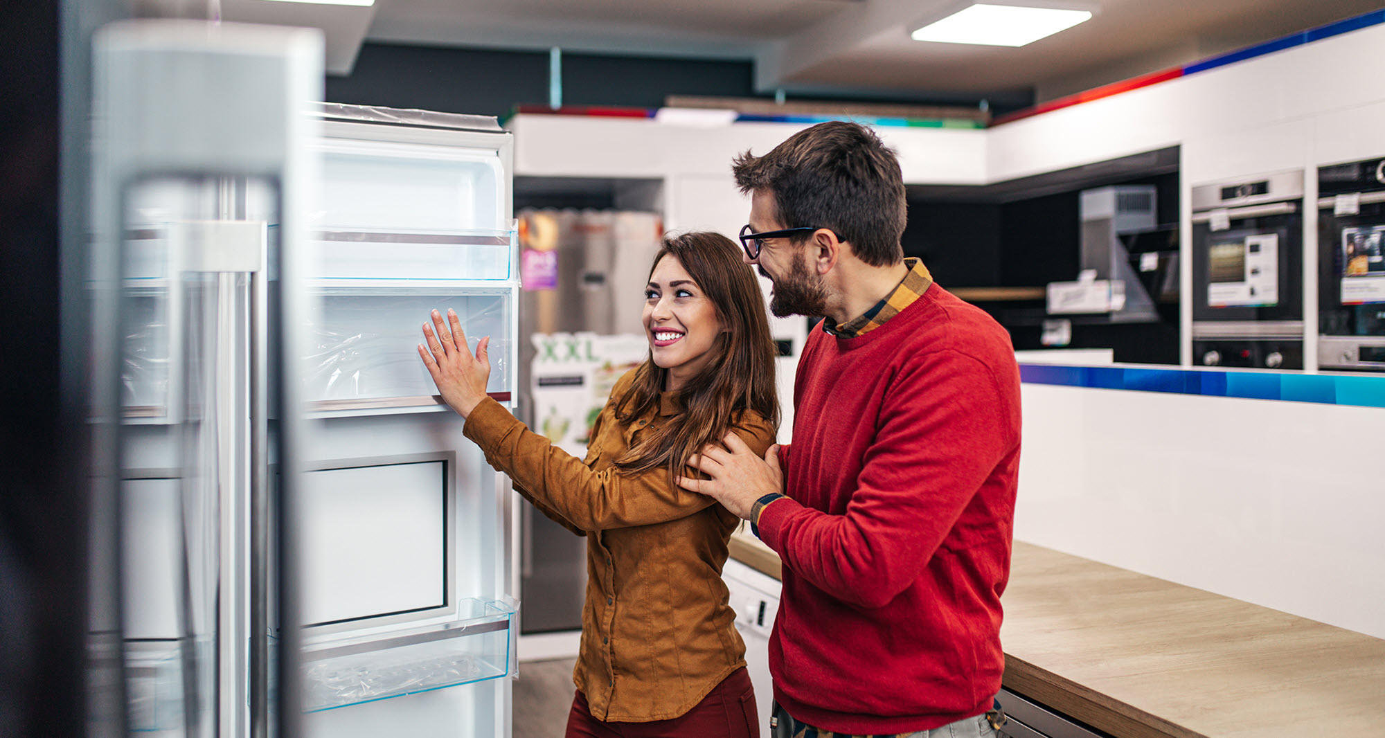 couple at an appliance store looking at a refrigerator