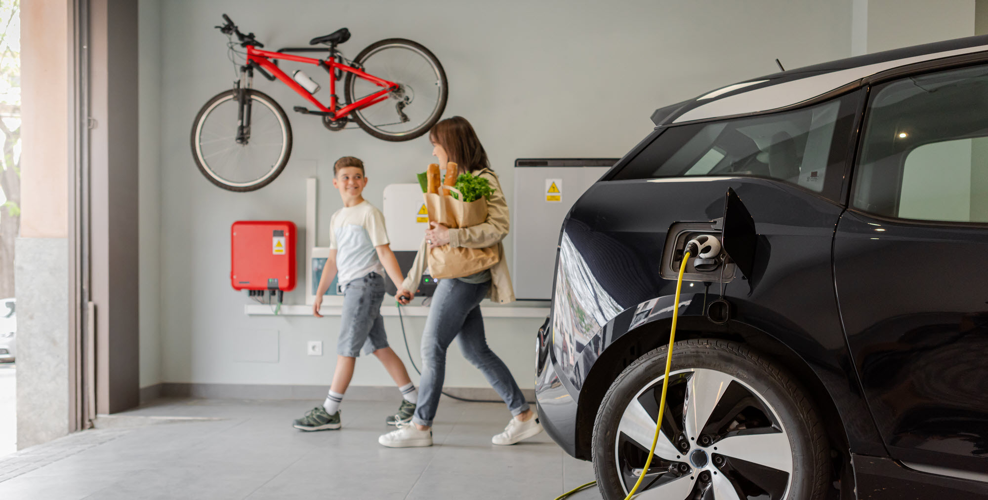 Mom and son in a garage with an EV