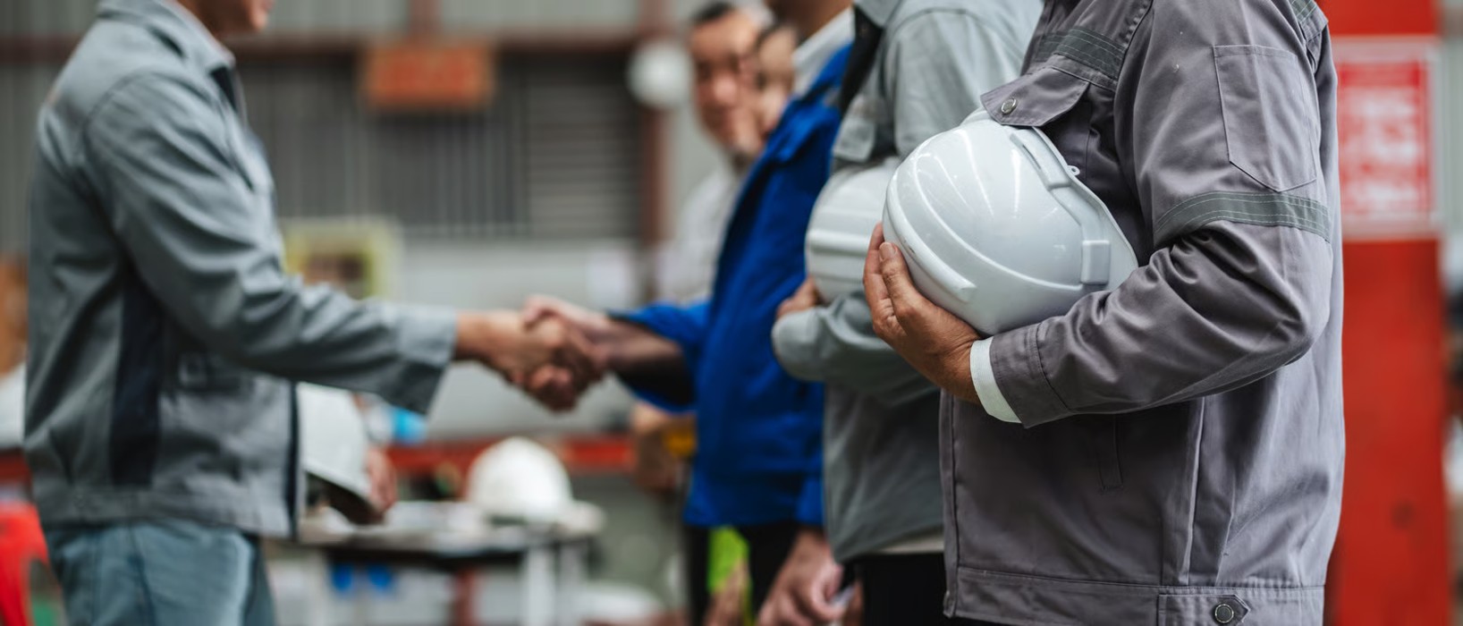 people in an industrial setting shaking hands
