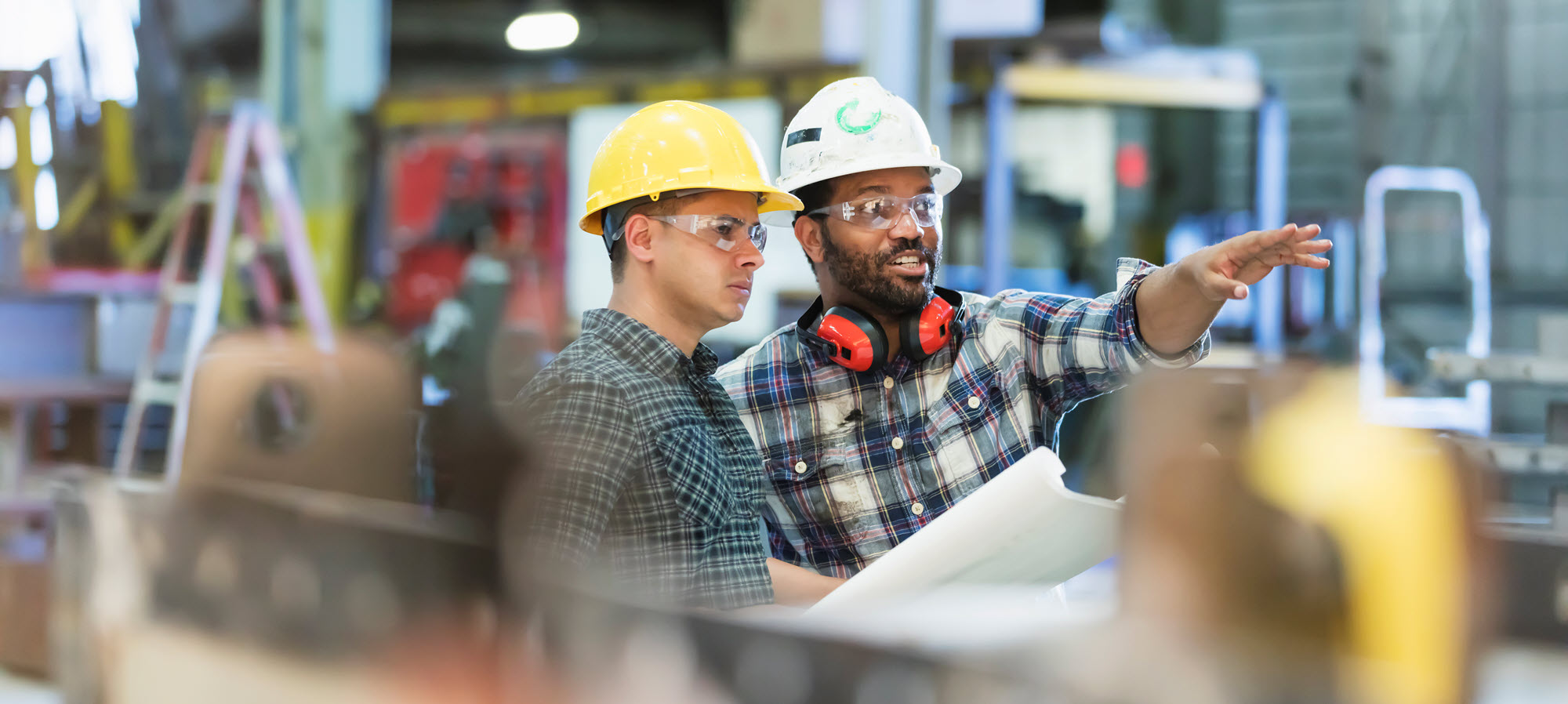 two men talking in a factory