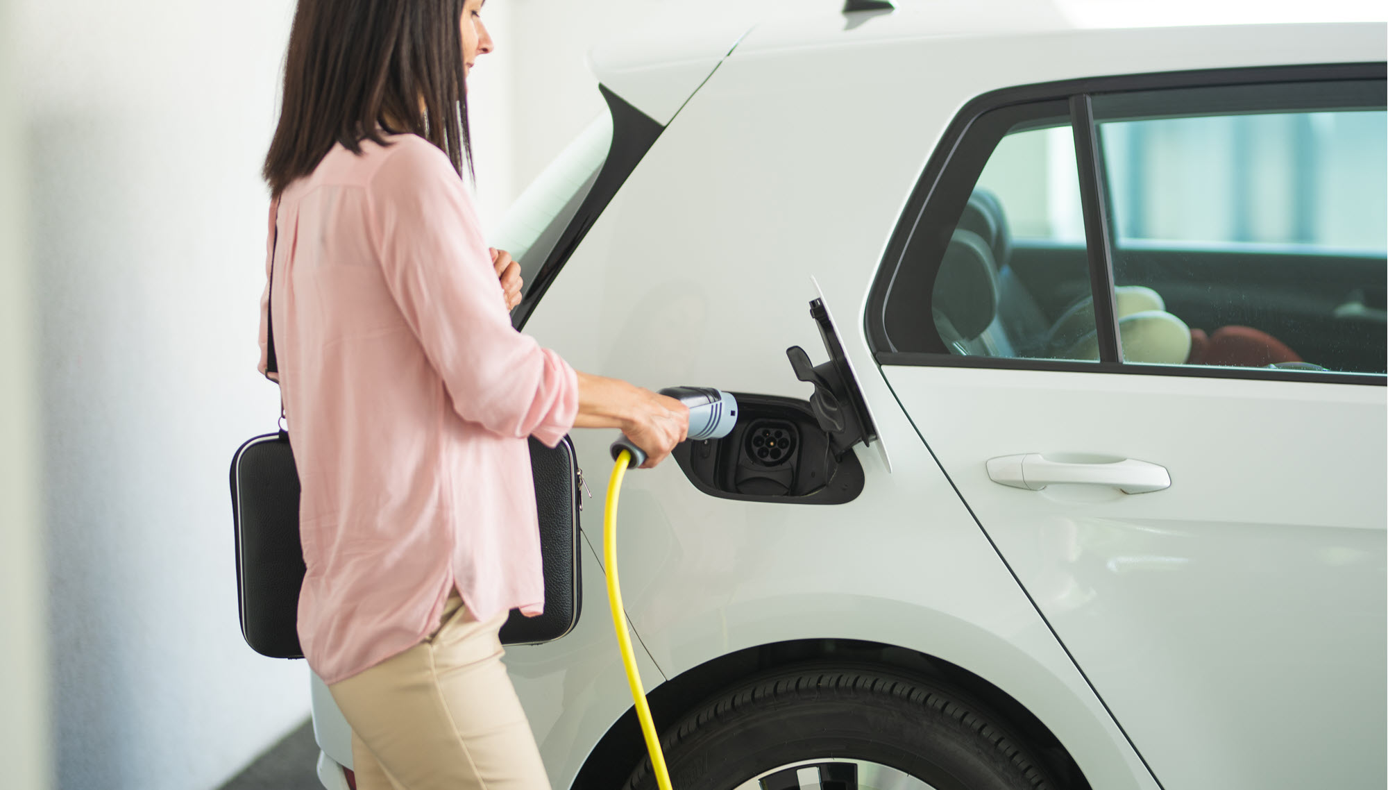 woman about to plug in a charger to an EV