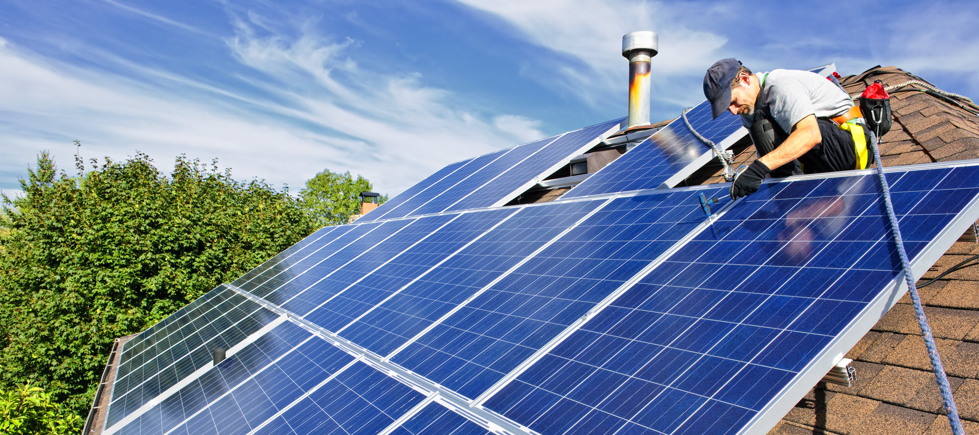 Worker installing rooftop solar panels
