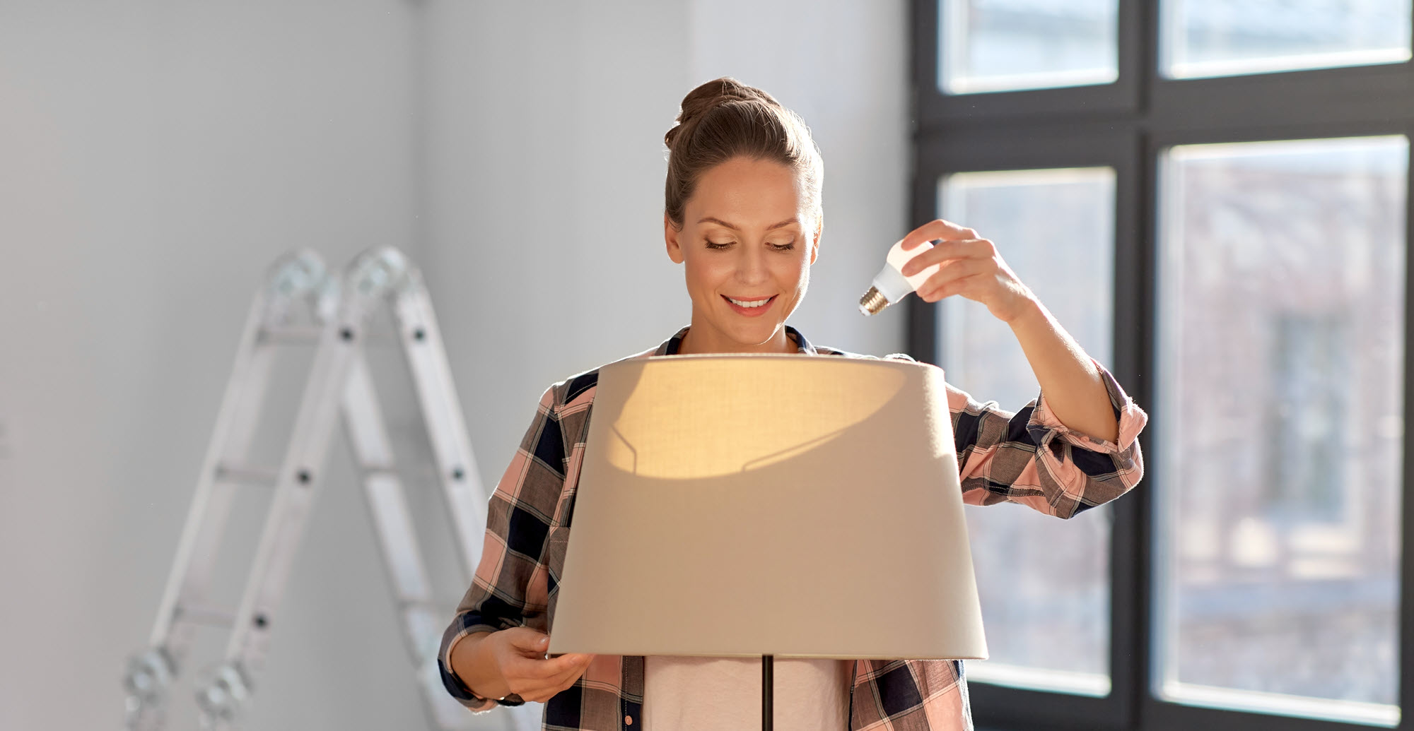 woman changing a light bulb in a lamp
